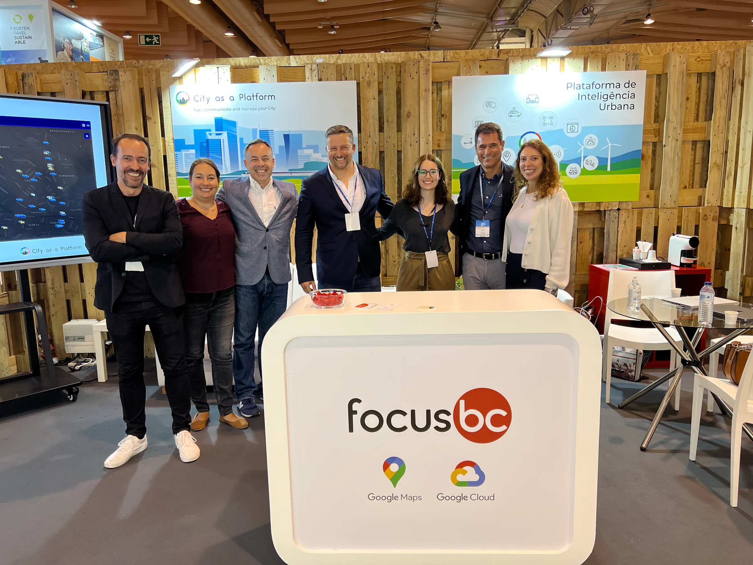 Focus BC team standing together at an exhibition booth promoting the City as a Platform urban intelligence solution, with Google Maps and Google Cloud logos displayed.