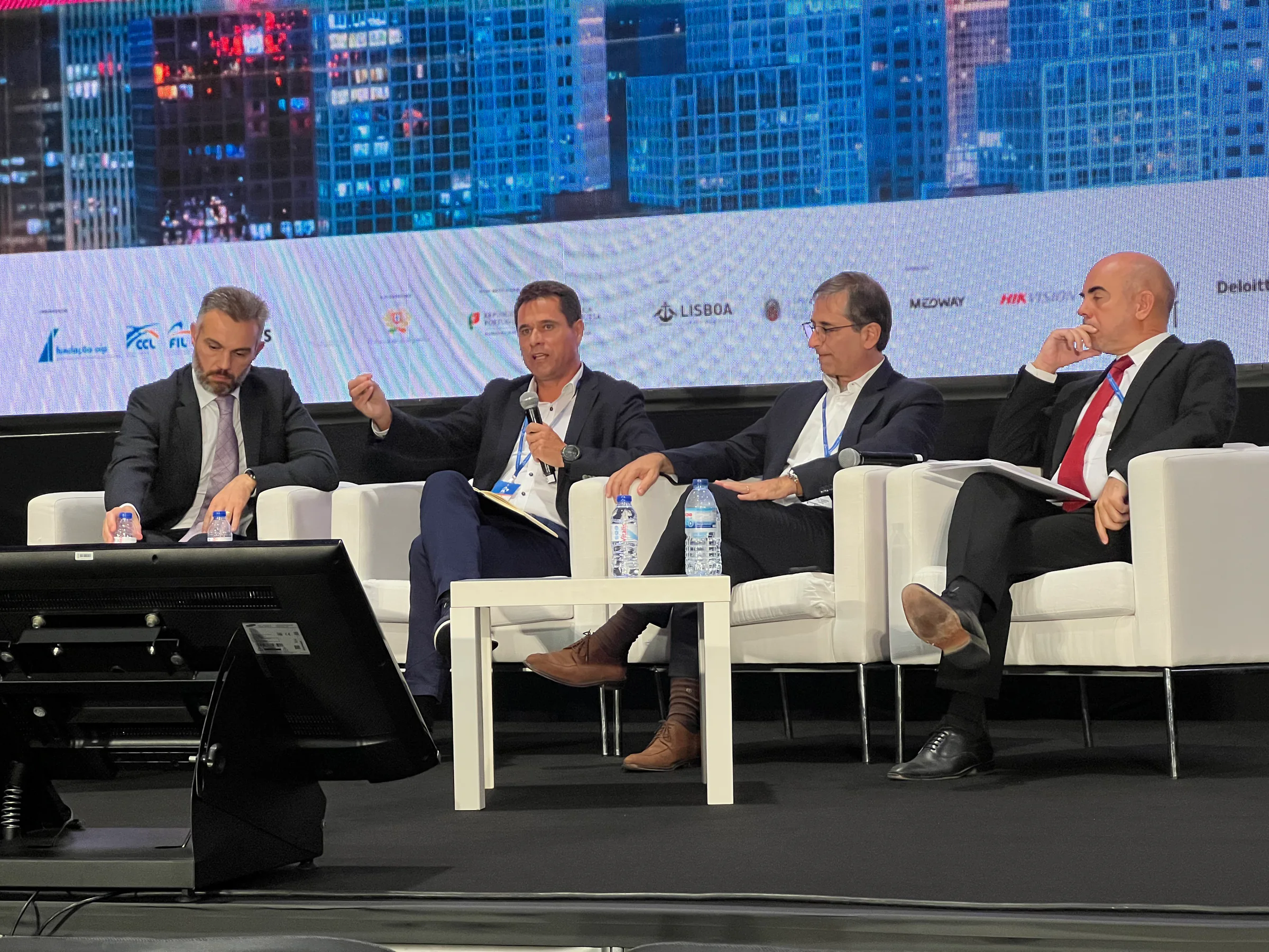 Exhibition stand showcasing a smart city command and control center with multiple data dashboards displayed on large screens and laptops.